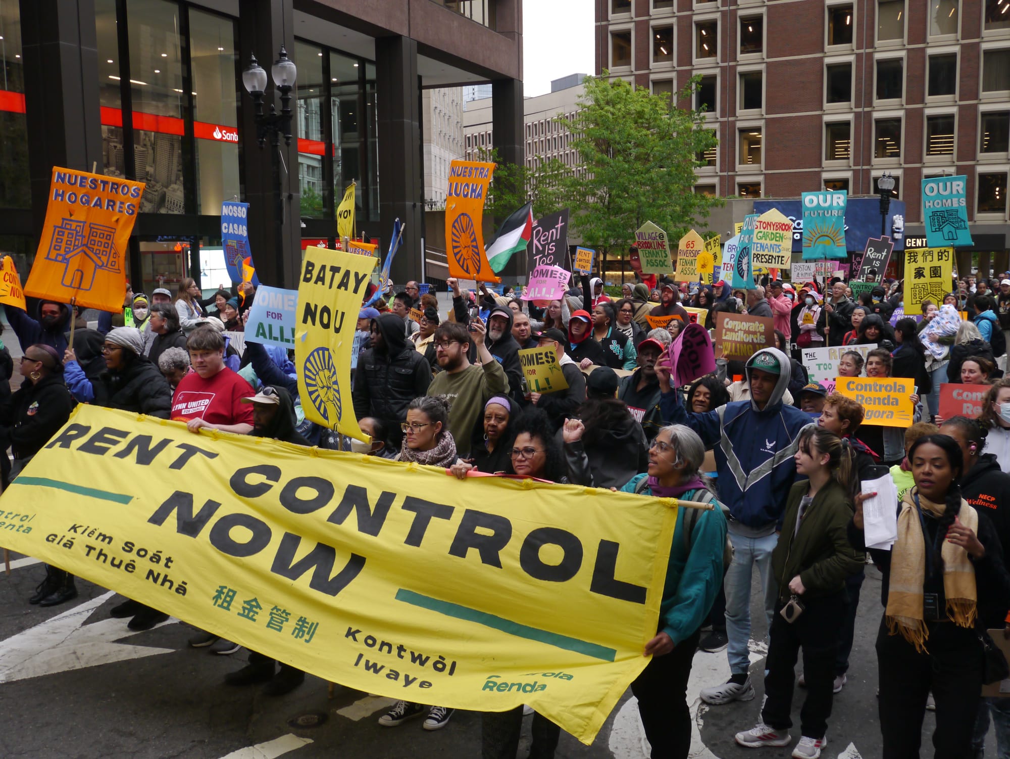 Housing activists march on Cambridge Street, carrying signs and banners calling for rent control.
