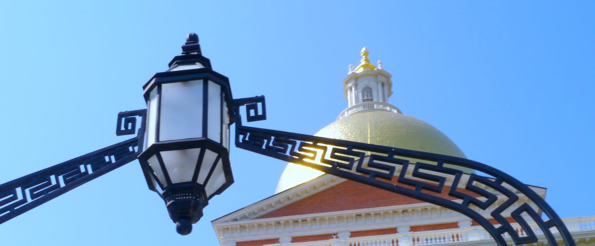 The State House dome and a lamp that hangs over the building's front gate.