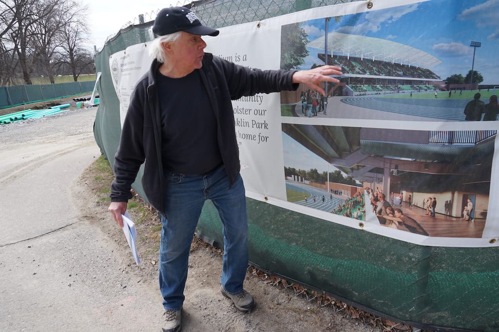 Abutter Alan Ihrer points to an architect's rendering showing a section of seats he says will not have sight lines on the track. 
