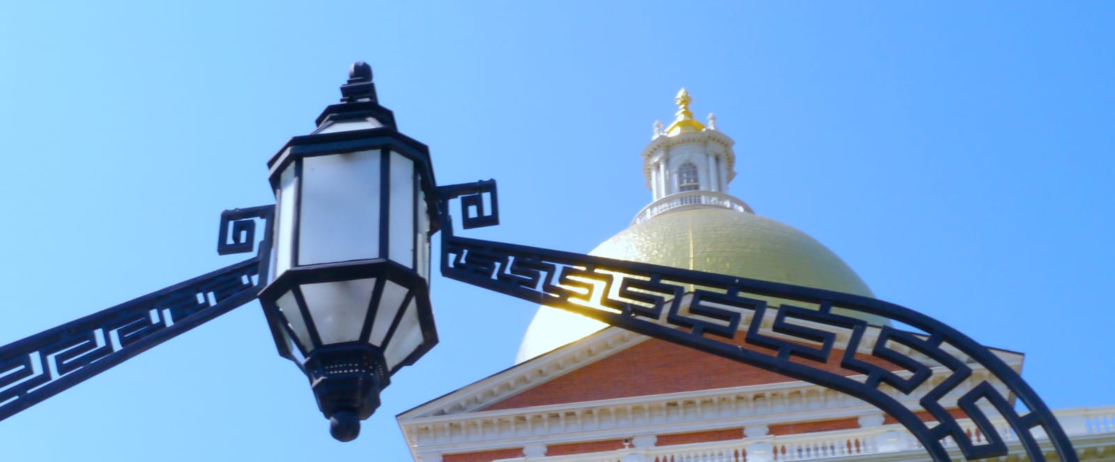 The State House dome and a lamp that hangs over the building's front gate.
