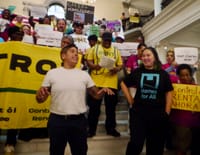State Rep. Sam Montaño and Carolyn Chou, executive director of Homes For All Massachusetts, lead a rally at the Grand Staircase in the State House.