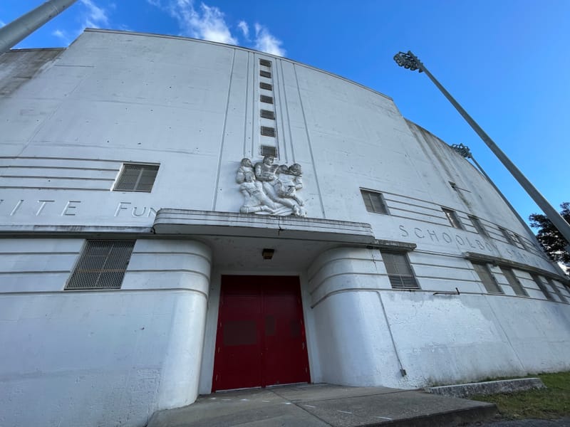The entrance to the west grandstand of White Stadium, showing the words "George White Fund Schoolboy Stadium and a bass relief of football players.