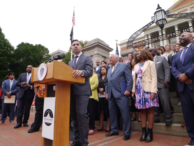 Representative Andy Vargas speaks at a podium backed by lawmakers during a Juneteenth celebration earlier this year.